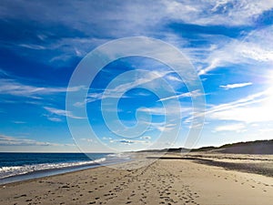 Foot Steps in the Sand with Bright Blue sky