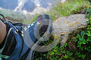 a foot in a traveler's shoe. mountain tourism. Hiker standing on top mountain