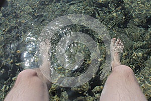 Noha voda přes šedá korály 