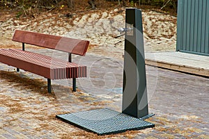 Foot washbasin near the beach. Foot washing device near the bench