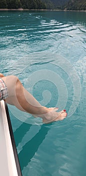 foot into the water sitting on the yacht