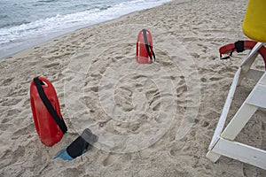 Foot of the white Lifeguard tower with rescue equipment, rescue can, and fins
