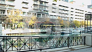 footage along the Ogden Slip waterway with boats and yachts docked, autumn colored trees, people walking and restaurants