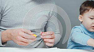 Footage of dad and little boy making animals from plasticine