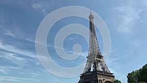 Footage of Eiffel tower international landmark and cultural icon in Paris. It is a sunny summer day.