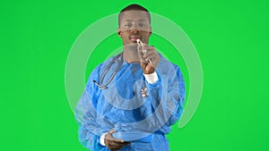 Footage of an ethnic male surgeon holding a pill with forceps