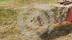 Footage of a hay bale maker working in the field