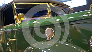 Footage of an old olive Peugeot car model at Retro Mobile exhibition at Porte de Versailles
