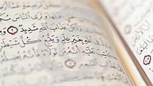 Footage of an open Quran, the focus moves along the opened page