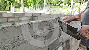 Footage real time close-up asian worker plastering external wall of building