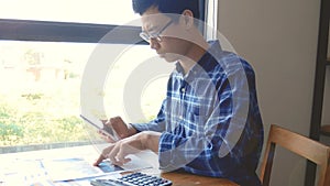 Footage, serious Asian business man working with paper work and calculator for calculations documents. business accounting people