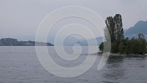 Footage taken from a boat over a misty lake an island.