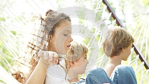 Footage of three Caucasian kids sitting together on Outdoor Mesh Hammock