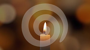 Footage of Using a match, light a candle on on a of colored blurred bokeh