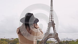 Footage of young tourist woman taking a photo of Eiffel Tower