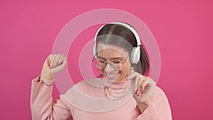 Footage of young woman wearing headphones and dancing while listening music