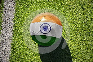 football ball with the flag of india on the green field near the white line