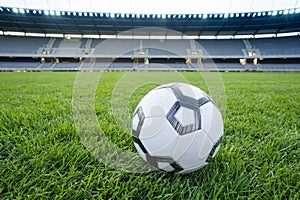 Football ball on fresh green grass pitch. Soccer ball at big stadium