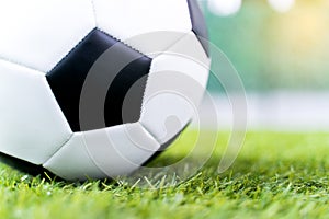 Football ball on green grass field background