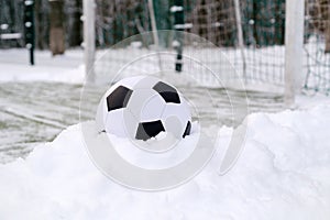 Football ball near soccer goal in winter