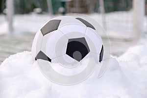 Football ball near soccer goal in winter