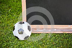 Football and blackboard on the grass of the pitch
