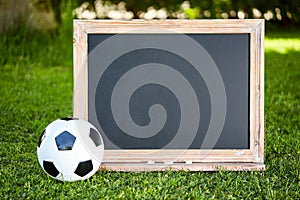 Football and blackboard on the grass of the pitch