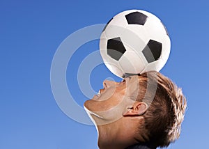 Football, bounce and head with man, sports and training with competition and exercise. Person, blue sky and player with