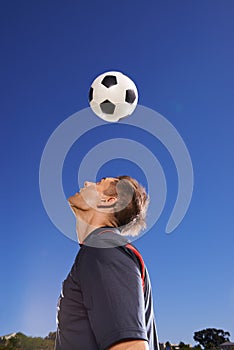 Football, bounce and head with man, training and technique with competition and exercise. Person, blue sky and player