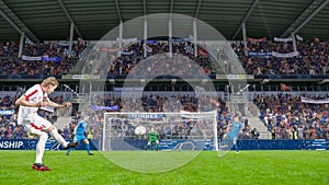 Football Championship: White Team Forward Hits the Ball and Scores Perfect Goal. Goalkeeper Jumps