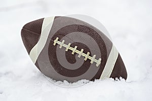 a football covered with snow and laying in the snow