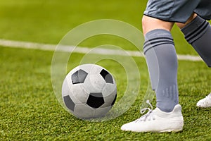 Football detail. Kicking the soccer ball. Football player feet on the grass pitch