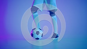 football dribbling ball in studio, player is showing professional skills, closeup of feet of player