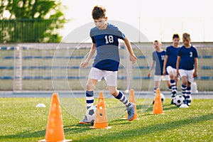 Football Drills: The Slalom Drill. Youth soccer practice drills. Young football players training on pitch