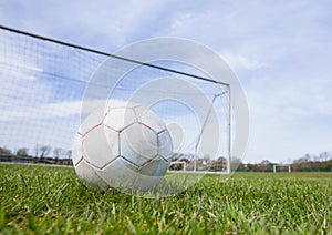 Football on an empty pitch in front of goal