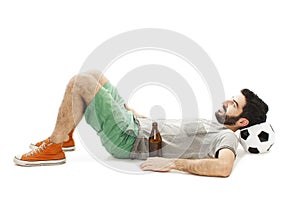 Football fan cheering happy watching television soccer match lying on floor head on ball