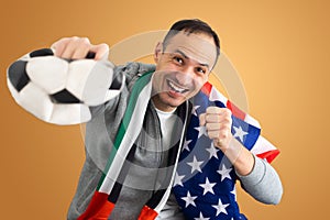 football fan with a deformed crumpled ball and with the flag of the UAE and the USA