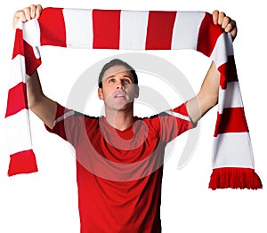 Football fan in red holding scarf