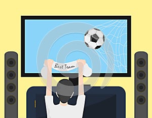 Football fan watching football on TV. Ball in net on TV screen.