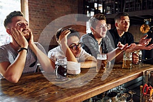 Football fans. People in casual clothes sitting in the pub