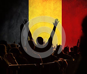 football fans supporting Belgium - crowd celebrating in stadium with raised hands against Belgium flag