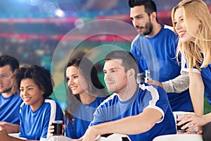 Football fans watching soccer match at stadium