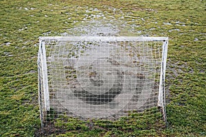Football field in bad conditions, the grass is waterlogged.