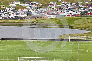 Football field in Faroe islands. Colorful village of Vagur, Suduroy