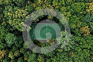 football field in summer deciduous forest, aerial