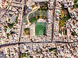 Football field surrounded by stone city. Turkey Malta. Aerial top view