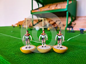 Football figures lined up on a grass field