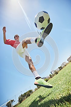 Football, fitness and soccer player training with a juggling exercise on soccer field, grass or football stadium. Sports