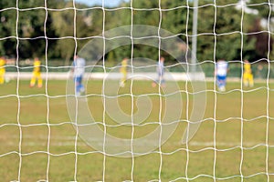 Football game arena through soccer nets. Blurred background