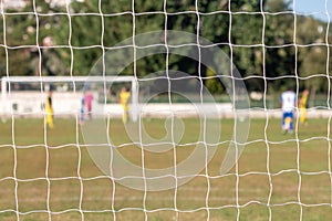 Football game arena through soccer nets. Blurred background